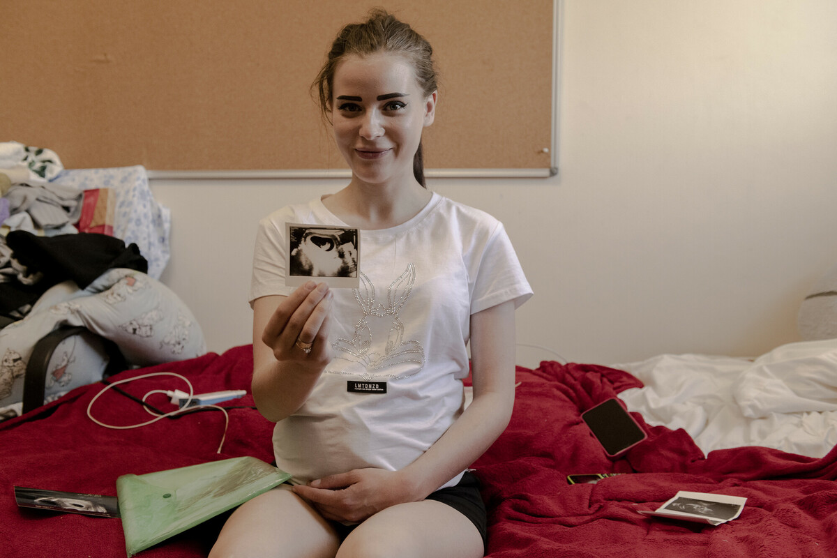Galyna,* 22, shows an ultrasound of her unborn baby at a shelter in a church being supported with DEC funding in Lviv in June 2022. Image: Kasia Strek/DEC