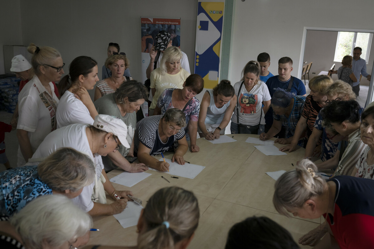 Refugees in Moldova fill in paperwork to receive food and hygiene kits provided by Communitas, a local partner of Action Against Hunger. Image: Andreea Campeanu/DEC