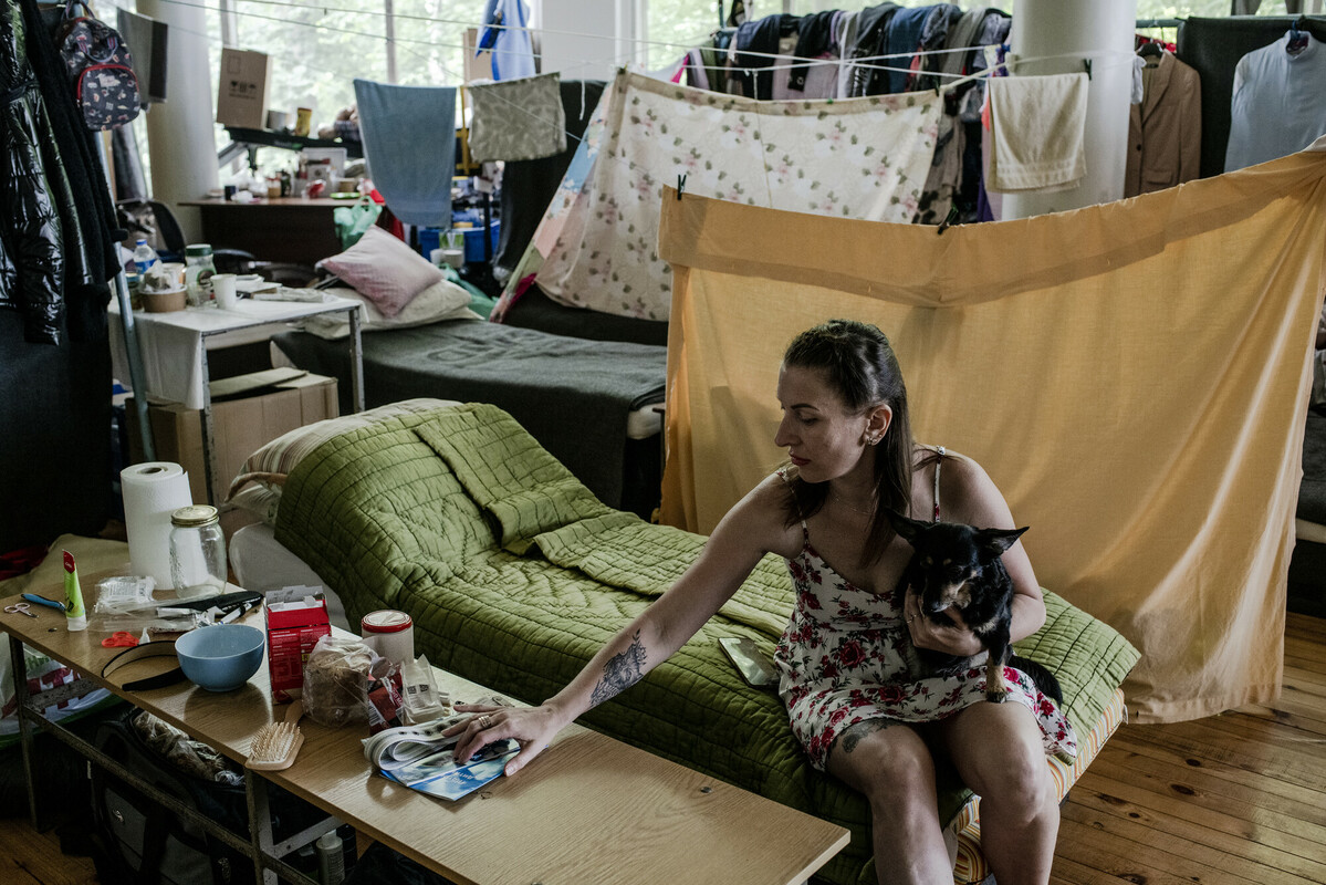 Kristina sits on her bed in a sports hall converted into a shelter for displaced people in Lviv in June 2022. Image: Kasia Strek/DEC
