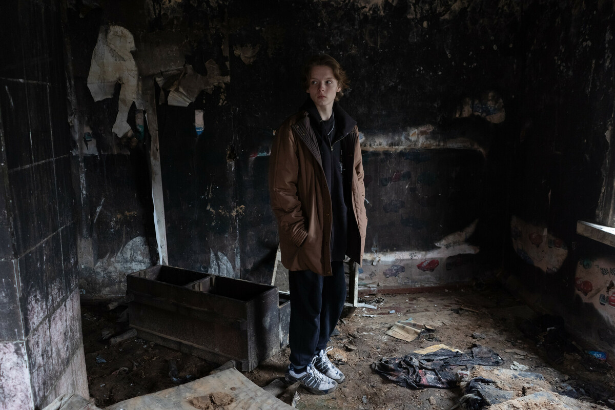 Olha’s* son Dymtro,* 15, stands in the ruins of their house that burned down over the summer near the border with Belarus. The family is receiving help from social workers funded by DEC charity Save the Children. Image: Anastasia Vlasova/Save the Children