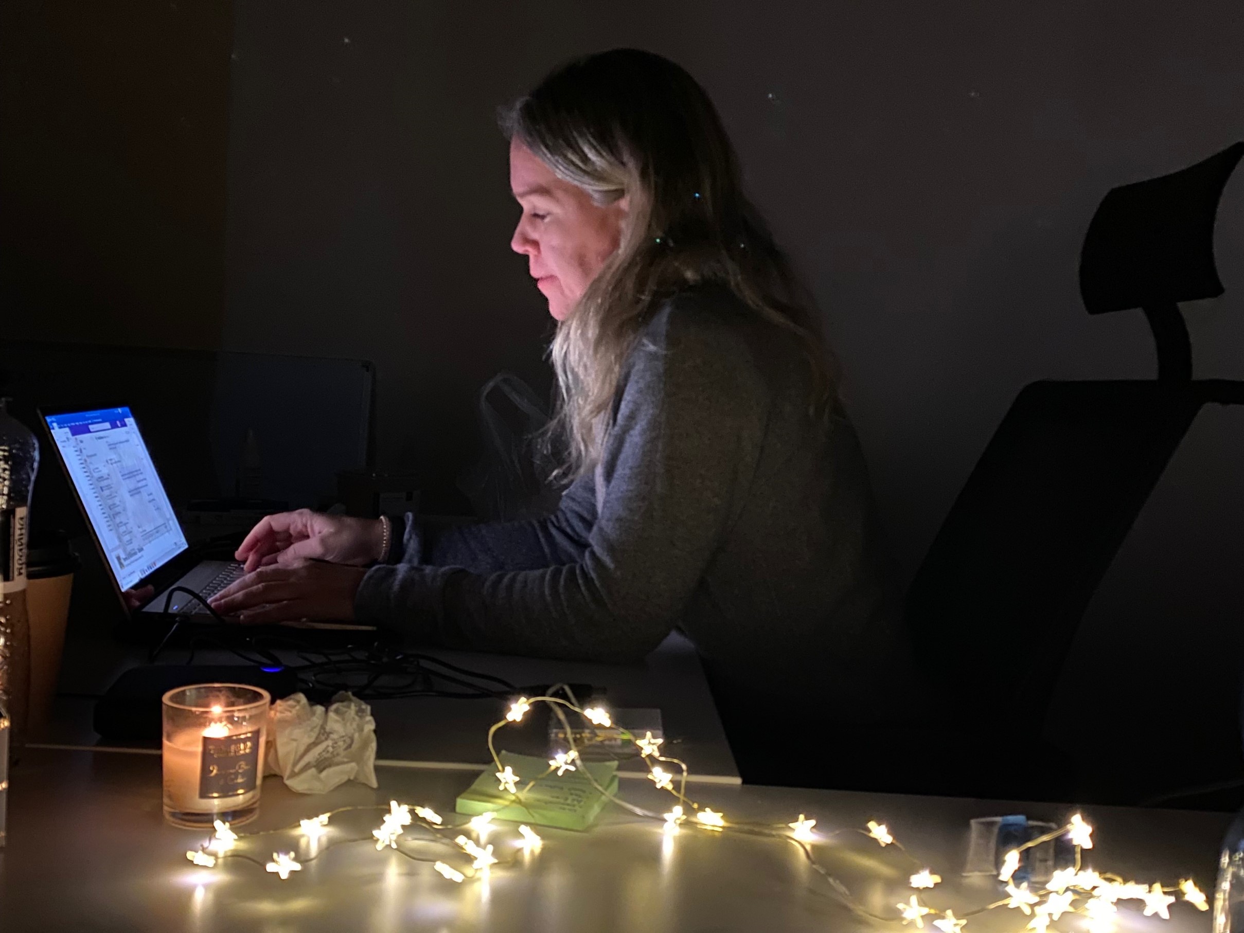 Marysia Zapasnik of International Rescue Committee uses candles and battery-powered fairy lights to keep working during a power cut at IRC’s office in Kyiv. Image: Tamara Kiptenko/IRC