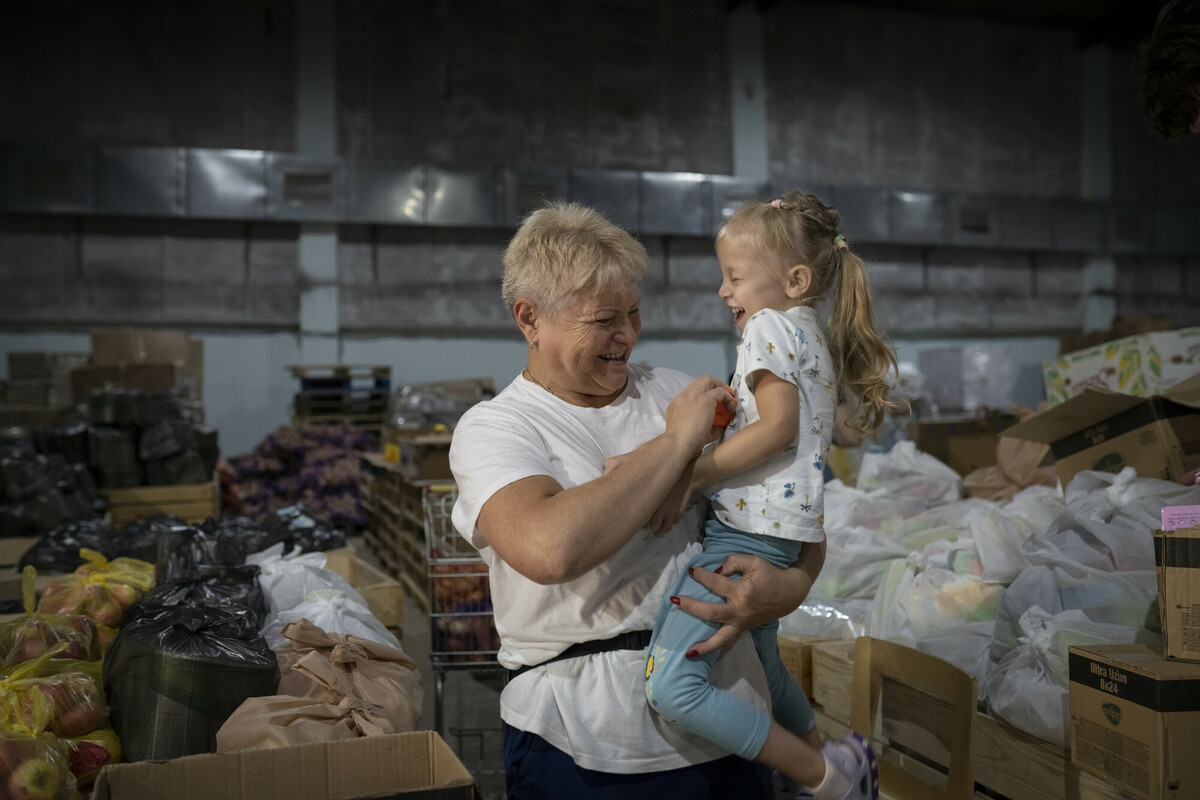 Tatiana, 60, a volunteer for Plan International partner Moldova for Peace, who is herself a refugee from Ukraine, plays with her granddaughter Alyssa, three, at a warehouse in Chisinau, Moldova. Image: Andreea Campeanu/DEC 